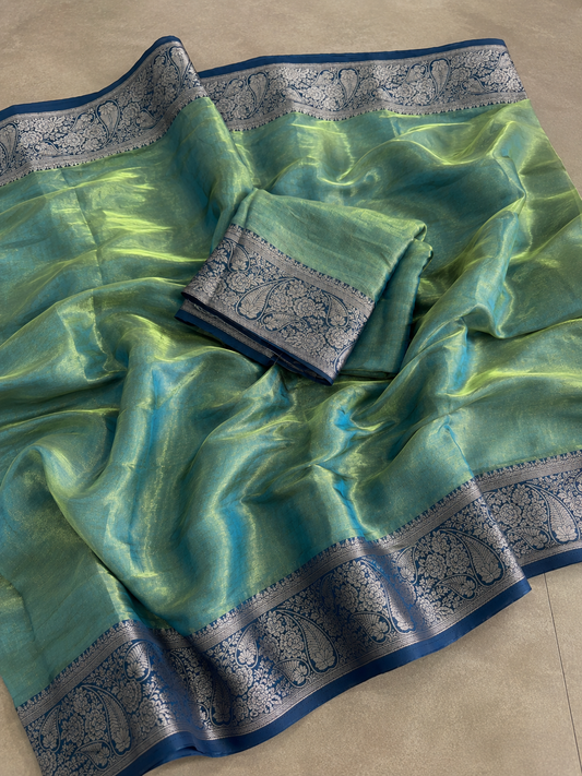 A green and blue silk saree with intricate silver zari paisley borders